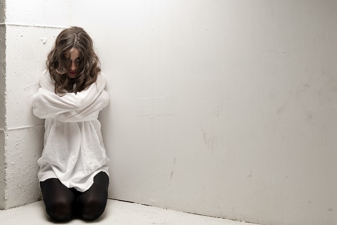 An Insane Woman With Straitjacket On Knees Looking At Camera