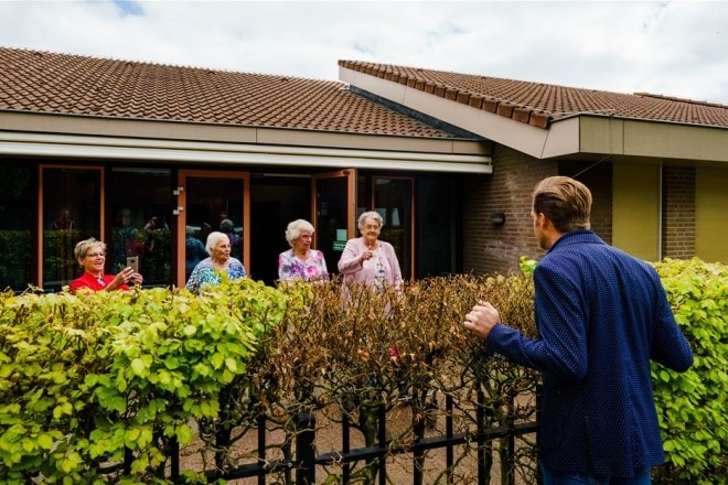 Minister Hugo de Jonge spreekt met bewoners van Centrum voor Wonen en Zorg Heidestede in Sint Willibrord. Foto: ANP Marco de Swart.