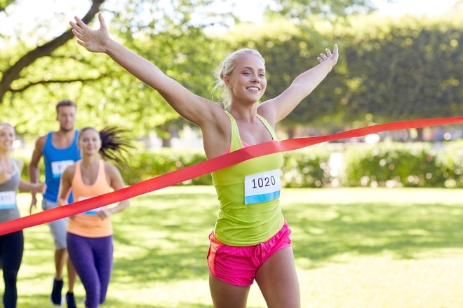 Happy Young Female Runner Winning On Race Finish