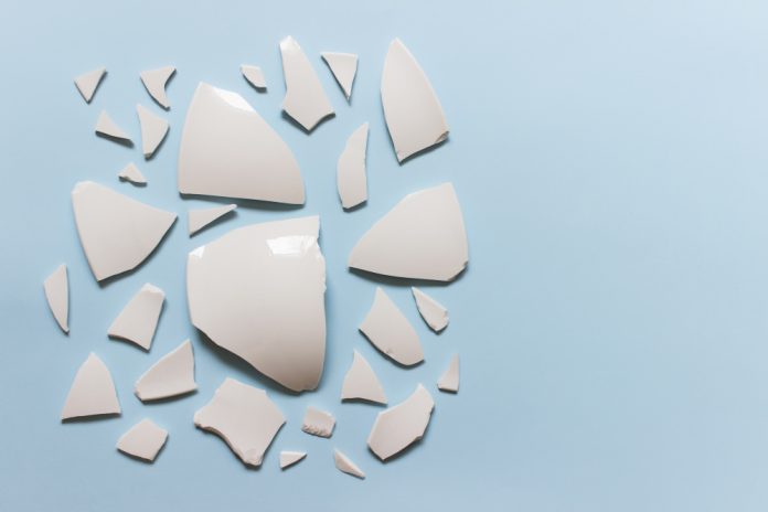 Broken Ceramic Porcelain Pieces On Blue Background