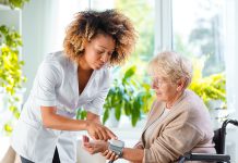 Home Nurse Checking The Blood Pressure Of The Elderly Lady