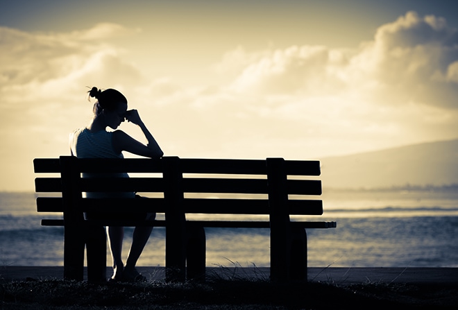 Lonely Woman Sitting Alone On A Bench
