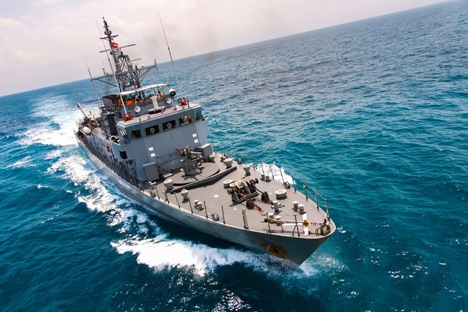 Military navy ships in a sea bay with fishing boat,view from aerial