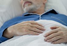 View Of Overworked Wrinkled Hands Of Wise Old Man Peacefully Drowsing In Bed