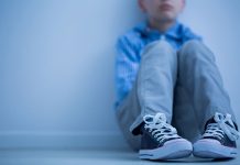 Sad Boy With Asperger's Syndromesits Alone