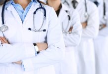 Group Of Modern Doctors Standing As A Team With Arms Crossed In Hospital Office. Physicians Ready To Examine And Help Patients. Medical Help, Insurance In Health Care, Best Desease Treatment And Medicine Concept