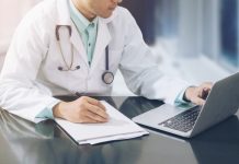 Doctor Working On Desk With Laptop