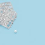 last pill. empty pill packaging. drug shortage deficiency concept. Empty packs of pills and last pill isolated on blue background. top view