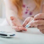 Measuring Blood Sugar Level Of Teen Girl With Glucometer