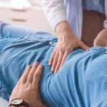 Gastroenterologist examining man in clinic