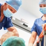 Chirurg spricht mit Patient im Krankenbett als Vorbereitung