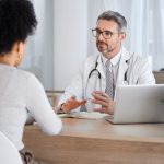 Healthcare, consultation and doctor talking to woman in after checkup, medical appointment and diagnosis. Wellness, support and medical worker in discussion with female patient in hospital or clinic