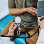 Close up of doctor measuring blood pressure of an elderly patient.
