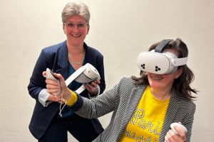 Op de foto staan beleidsadviseur Mirjam Broerse en universitair hoofddocent Sietkse Sikkes met de VR-apparatuur