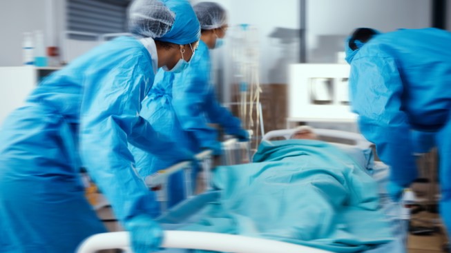 Women, man and hospital bed in motion blur of emergency surgery, healthcare wellness or risk condition operation. Doctors, nurses and medical workers with patient in busy er, theatre room or teamwork