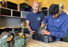 Cliënten nemen afvaltransport over van Renewi: ecostraat bespaart tonnen en vergroot participatie In de demontageloods van de ecostraat halen begeleider Patrick en deelnemer Dani een oude radio uit elkaar.